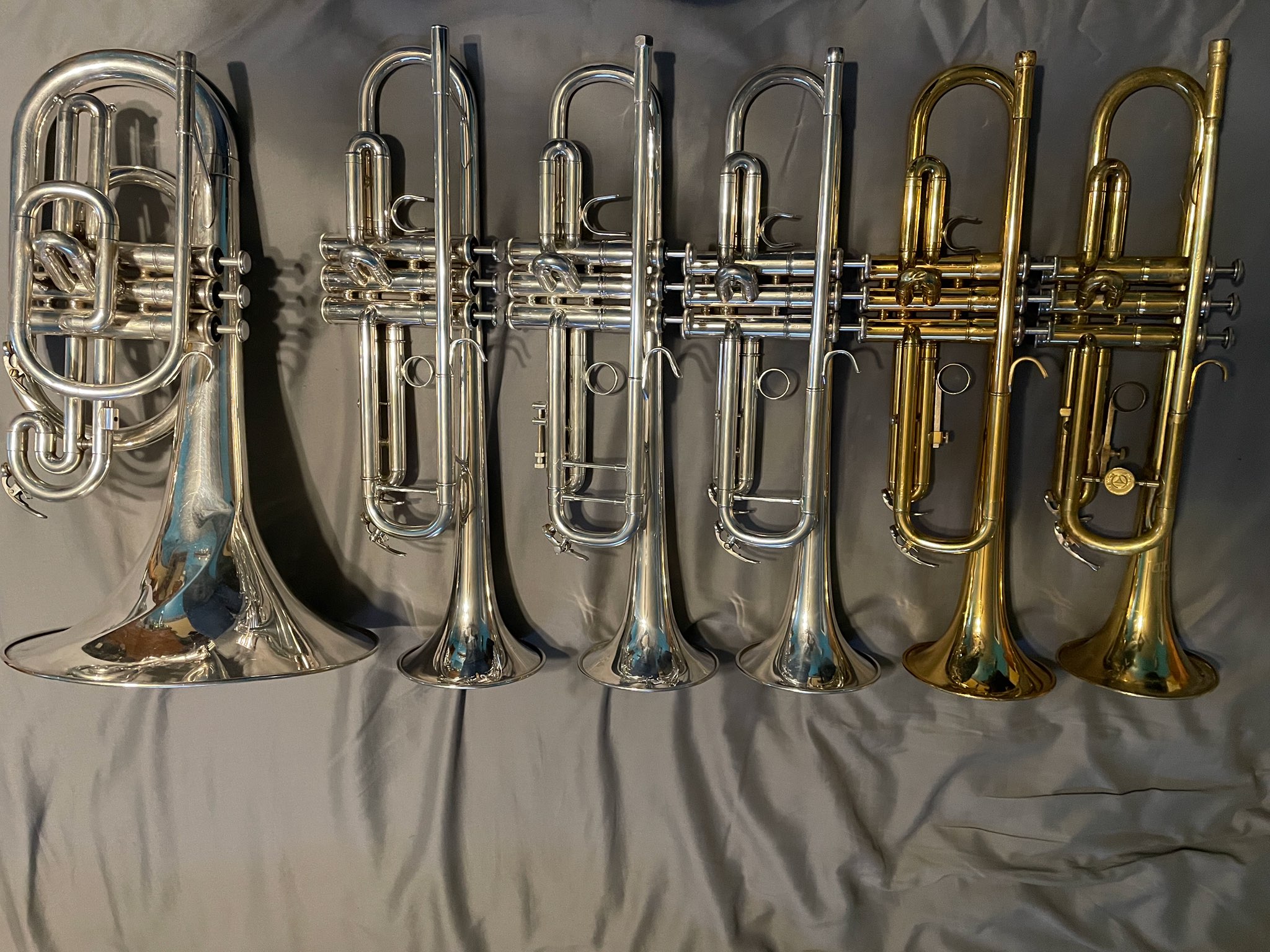 Row of newly cleaned trumpets and a mellophone.